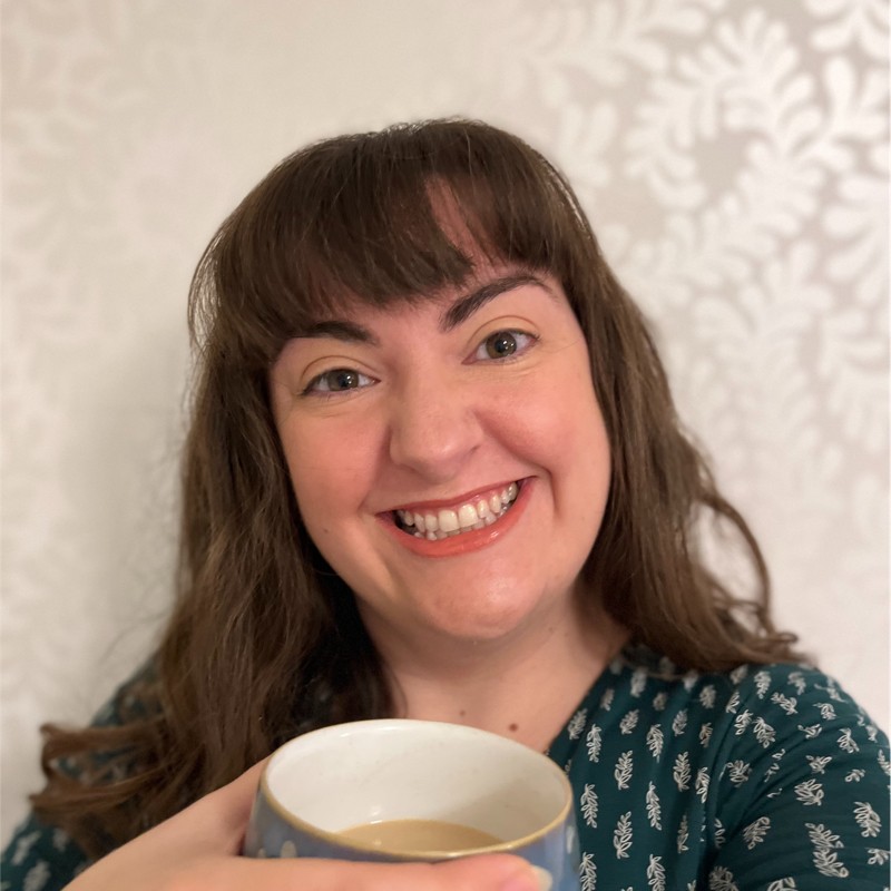picture shows an image of Beth Marshall smiling and holding a cup of coffee